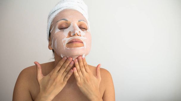 Caucasian  woman apply white cosmetic facial mask. Negative space or copy space for text. - Photo, Image
