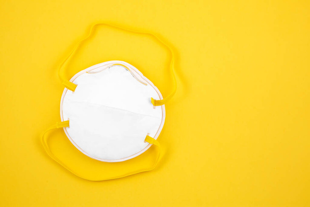 Maska do noszenia ochrony przed zarazkami Coronavirus lub covid 19 dla lekarzy i szpitali w izolacji na żółtym tle. - Zdjęcie, obraz