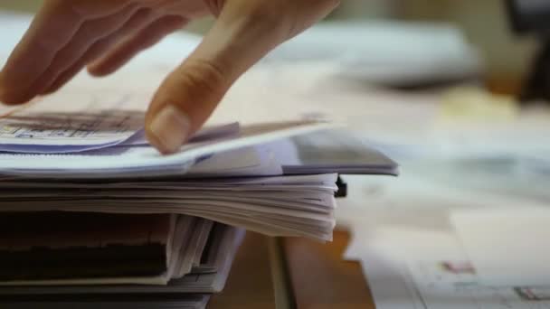 Búsqueda manual masculina en los documentos en papel. Informe financiero. Organización de archivos. Desorden de oficina - Imágenes, Vídeo