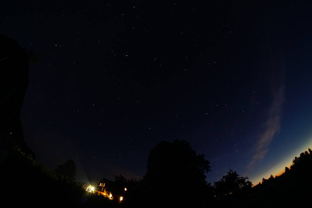 Blauer dunkler Nachthimmel mit vielen Sternen. Nachthimmel über der ländlichen Landschaft. Hohe ISO-Landschaft mit Fischaugenobjektiv - Foto, Bild