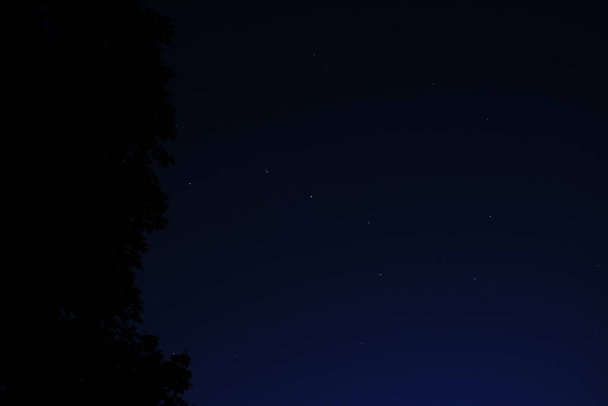 Блакитне темне нічне небо з багатьма зірками. Нічне небо над сільським пейзажем. високий ISO ландшафт з лінзою
 - Фото, зображення