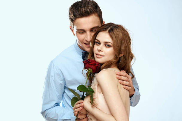 Homme et femme avec une rose rouge sur un fond clair amour famille câlins - Photo, image