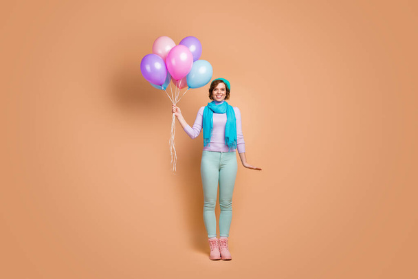 Full length body size view of her she nice attractive lovely pretty charming glad cheerful cheery girl holding in hands bunch air balls isolated over beige pastel color background - Foto, Imagem