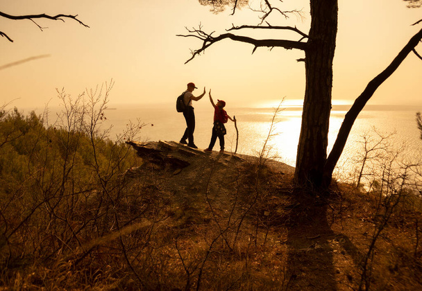  two people  have hiking  through seacast on sunset - Φωτογραφία, εικόνα