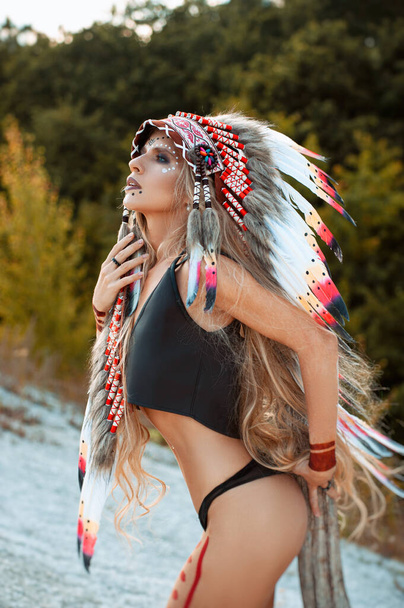 自然の中でヌードをポーズしているアメリカ先住民のイメージを持つ女性が - 写真・画像