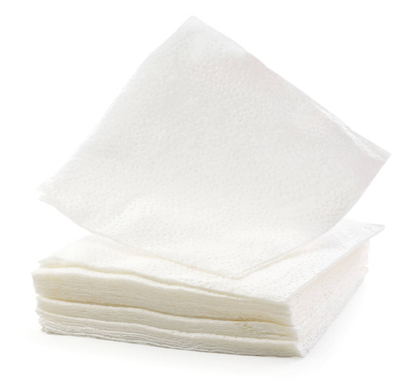 tas de serviettes carrées en papier blanc gros plan sur un fond blanc. Isolé - Photo, image