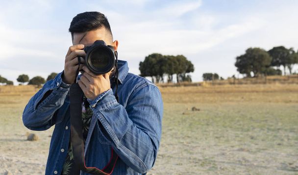 attractive boy photographer taking photos in nature - 写真・画像