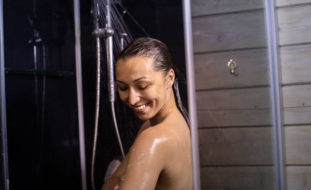 hymyilevä alaston nuori nainen nauttii virtaava vesi, suihkussa - Valokuva, kuva