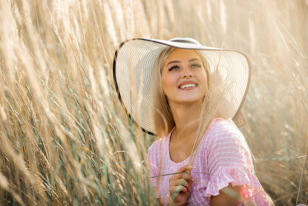 beautiful young woman in hat in summer field - Fotografie, Obrázek