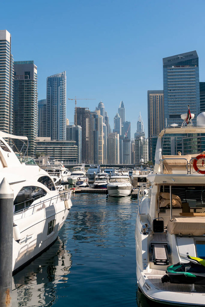Jacht a mrakodrapy nad vodou Perského zálivu v okrese Dubai Marina v SAE - Fotografie, Obrázek