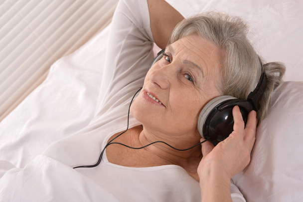 Senior lady in headphones - Фото, изображение