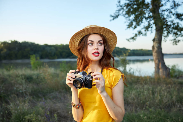 Женщина фотограф в шляпе красные губы смотрит на природу свежий воздух - Фото, изображение