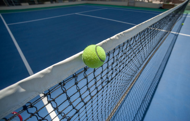 La pelota de tenis está suspendida en la banda de la cabeza. - Foto, imagen