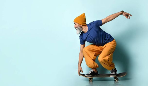 Stylish hipster bearded man with skateboard. - Foto, afbeelding