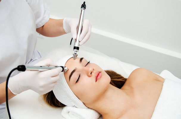 Woman getting ultrasound face beauty treatment in medical spa center. Skin rejuvenation concept - 写真・画像