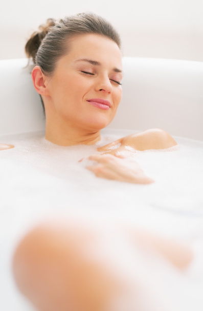 Happy young woman relaxing in bathtub - Фото, изображение