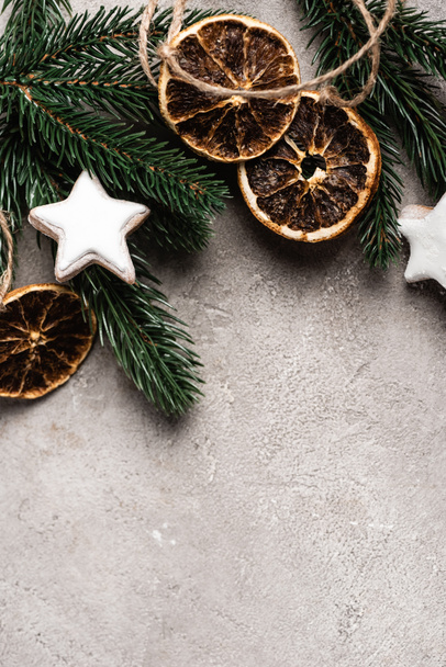 Top view of dried orange slices, cookies and pine branch on textured background - Photo, Image