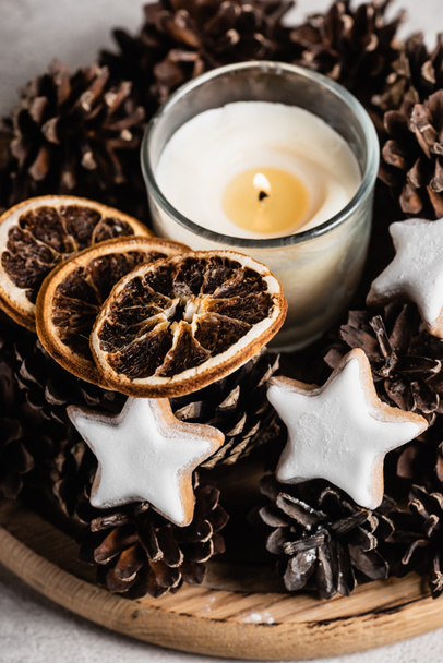 Scented candle with pine cones, dried orange slices and cookies - Foto, Imagem