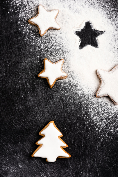 Top view of christmas gingerbread cookies covered with sugar powder  - Foto, Bild