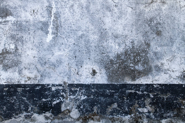 Old white painted concrete wall with dark baseboard, grunge background or texture  - Photo, Image