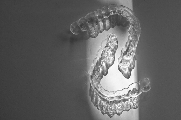 Moderní zubní průhledné rovnátka nebo rovnátka pro narovnání zubů v kosmetické zubní lékařství a ortodoncie s trendy stíny květin, selektivní zaměření - Fotografie, Obrázek