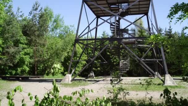 view tower made of steel in the green forest, filmed from bottom, camera tilts to the top of the tower, summery atmosphere with blue sky, 4k UHD, 25p - Footage, Video