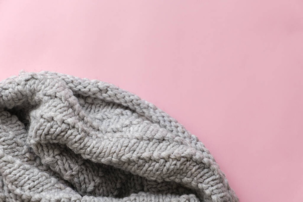 Grey knitted scarf on pink background with copy space for text. Flat lay, top view - Zdjęcie, obraz