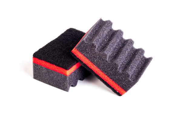 éponges pour laver la vaisselle en caoutchouc mousse noire avec une bande rouge et une surface ondulée. Gros plan. Isoler - Photo, image