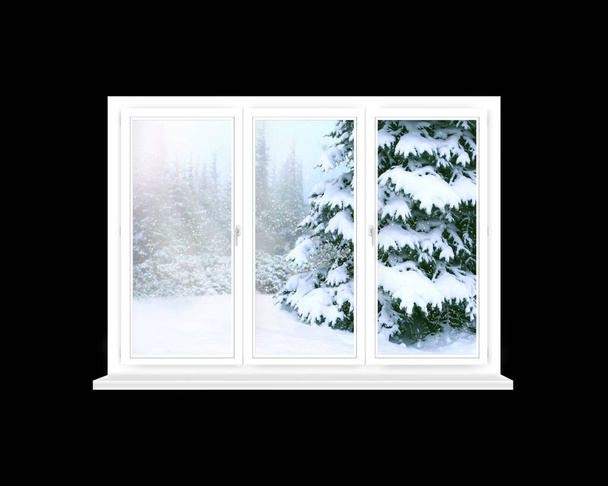 Ventana con vistas al bosque de invierno. Panorama a los árboles nevados desde las ventanas de la habitación. Ventana con vista a los árboles de Año Nuevo cubiertos de nieve. Ventana blanca en habitación oscura - Foto, imagen