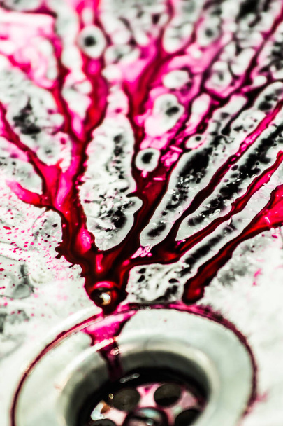 Spilled ink for refilling cartridges flows into the sink drain. Pink background. Pink abstraction. - Фото, зображення