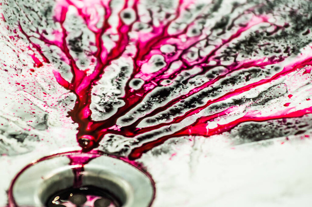 Spilled ink for refilling cartridges flows into the sink drain. Pink background. Pink abstraction. - Photo, Image