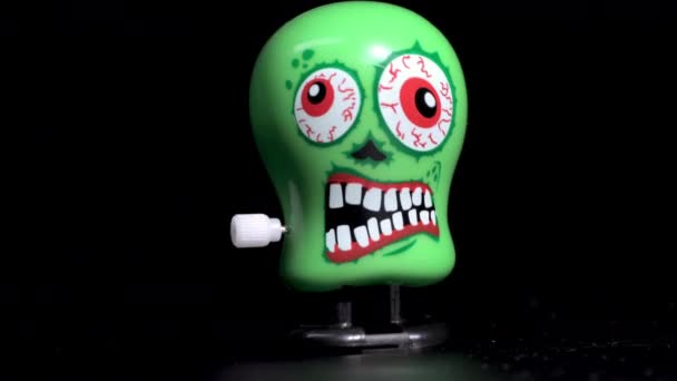 Grüne wickeln Totenkopfspielzeug auf, das sich an der Oberfläche bewegt - Filmmaterial, Video