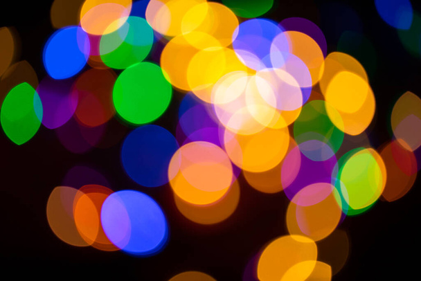 Christmas multicolored lights in defocus on a dark background - Photo, Image