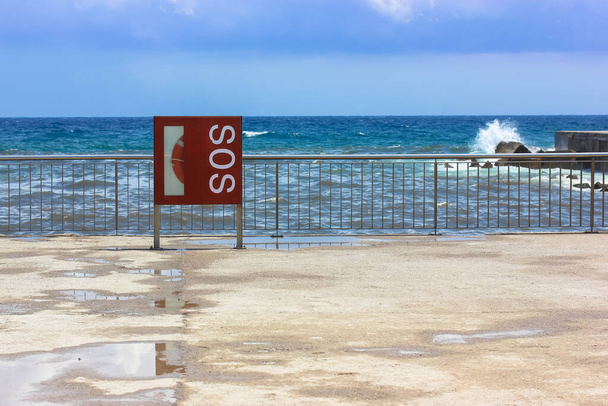 Figyelmeztető jelzés SOS felirattal a tengerparton: figyelmeztetés arra, hogy veszélyes úszni - Fotó, kép