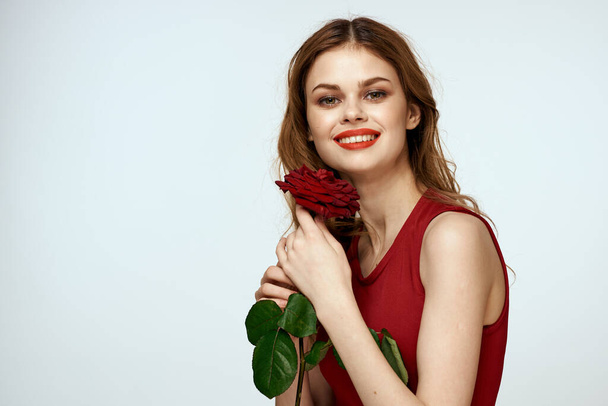 Pretty woman with rose in her hands charm gift lifestyle studio light background - Фото, зображення