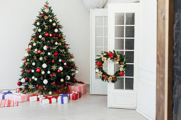 pin sapin de Noël avec des cadeaux pour la nouvelle année à l'intérieur de la chambre blanche - Photo, image