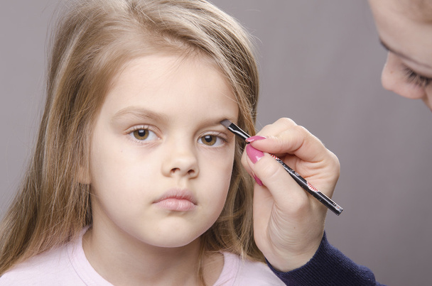 Maquiagem artista traz sobrancelhas no rosto da menina
 - Foto, Imagem