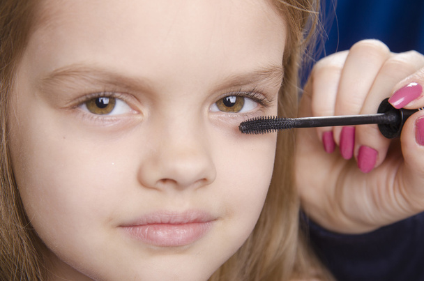 Makeup artist paints eyelashes on girl's face - Photo, Image