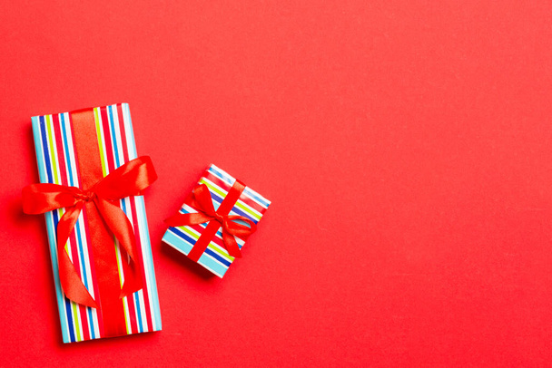 Вид зверху Різдвяна подарункова коробка з червоним бантом на червоному тлі
. - Фото, зображення