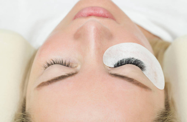 Eyelash extension procedure. A woman's eye with long lashes. Lashes, close-up, macro, selective focus. - Fotoğraf, Görsel