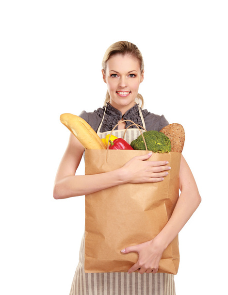 Woman in apron holding grocery bag - Foto, afbeelding