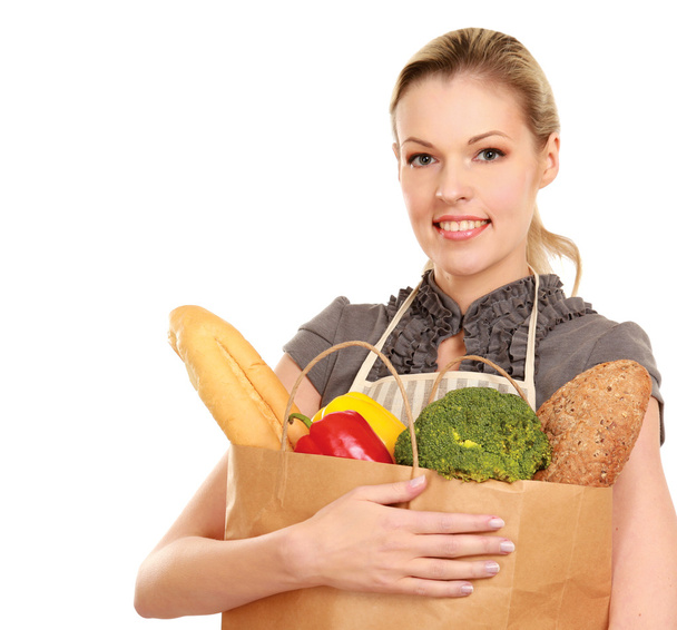 Woman in apron holding grocery bag - Photo, Image
