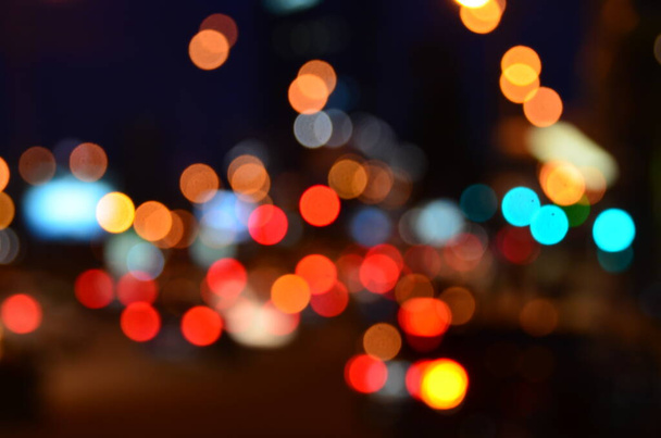 rozostřený snímek pouličních budov a silničního provozu osvětlený v noci - Fotografie, Obrázek