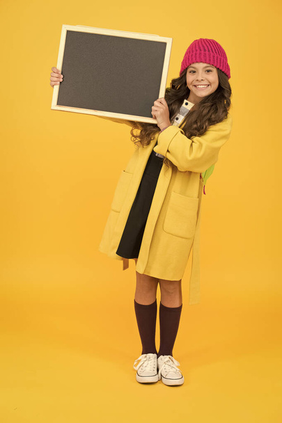 smiling child craving for education. retro and modern school. just look here. stylish schoolgirl blackboard. copy space for ad. happy pupil kid yellow wall. back to school. desire for study - Foto, immagini