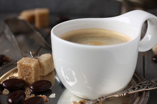 φλιτζάνι καφέ, κύβους ζάχαρη και σοκολάτα καραμέλα σε παλιά ξύλινα φόντο - Φωτογραφία, εικόνα