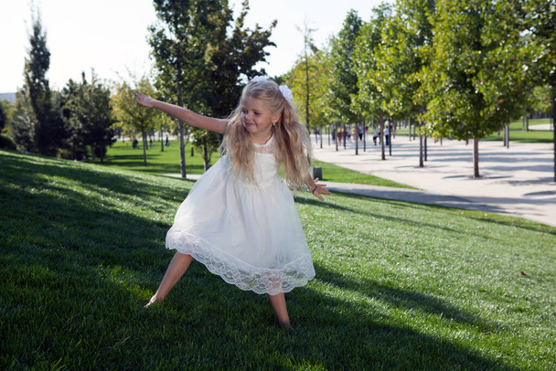 niña en un vestido blanco en el jardín verde - Foto, Imagen