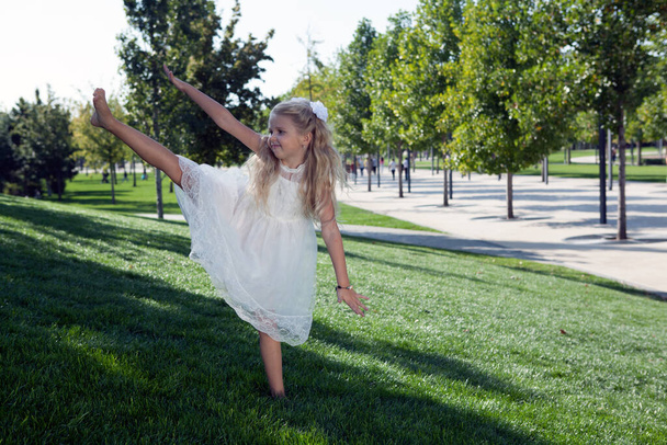 petite fille dans une robe blanche dans le jardin vert - Photo, image