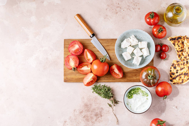Świeża grecka sałatka z serem feta podawana z pomidorami i sosem tzatziki. Widok z góry, płaski. Przestrzeń kopiowania - Zdjęcie, obraz
