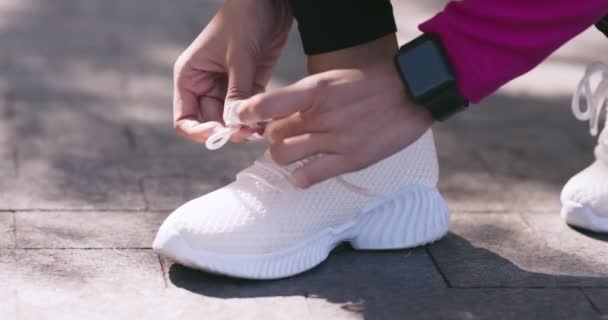 close-up van vrouwelijke runner koppelverkoop veters op witte sneakers en weglopen, slow motion - Video