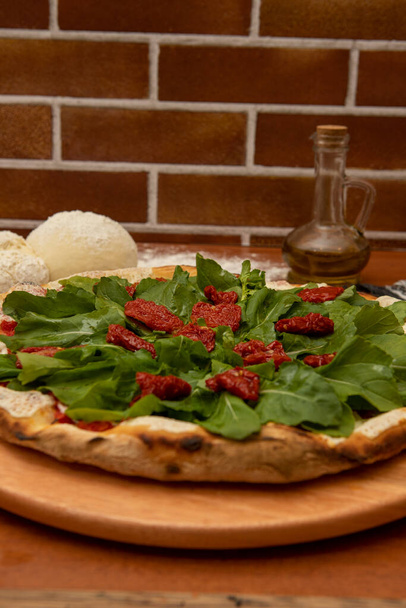モッツァレラ、ルッコラ、ドライトマトのピザ - 写真・画像